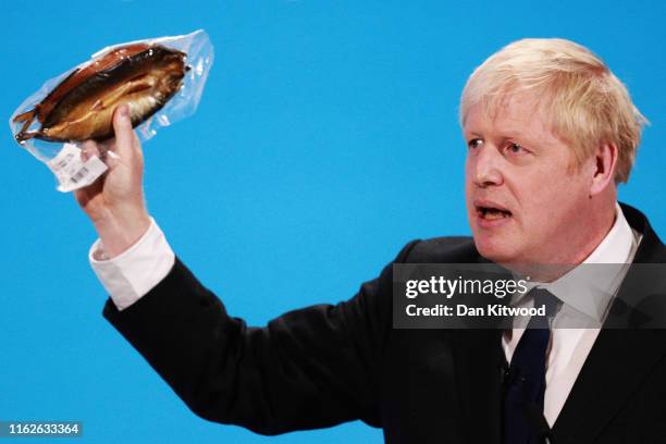 Boris Johnson holds a kipper to help illustrate a point as he talks at the final hustings of the Conservative leadership campaign at ExCeL London on...