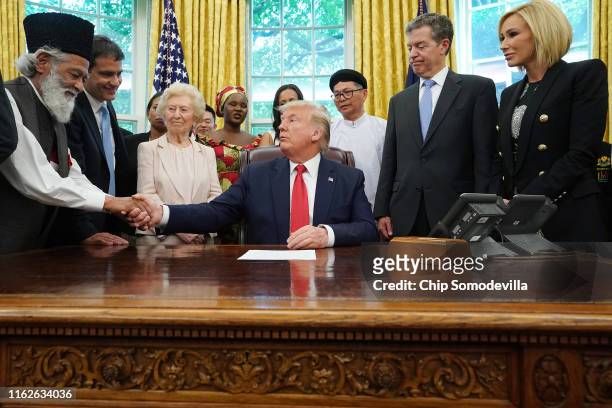 President Donald Trump shakes hands with Abdul Shakoor, an Ahmadiyya Muslim from Pakistan, while hosting survivors of religious persecution from 17...