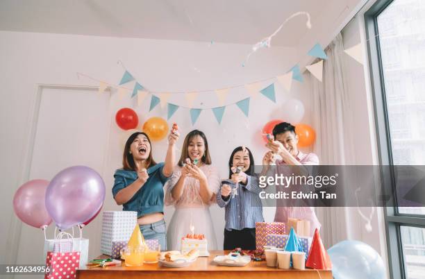 een groep vrienden viert een aziatische chinese vrouwelijke collega verjaardag - party popper stockfoto's en -beelden