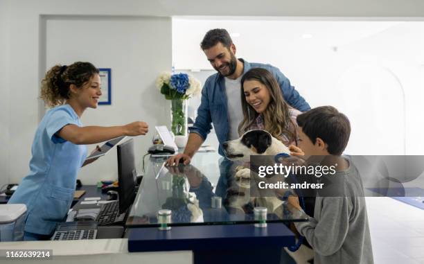 happy family taking their dog to the vet - vets surgery stock pictures, royalty-free photos & images