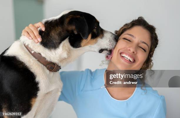 very happy veterinarian getting a kiss from a dog - dog kiss stock pictures, royalty-free photos & images