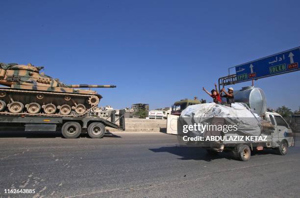 Convoy of Turkish military vehicles passes through Maaret al-Numan in Syria's northern province of Idlib reportedly heading toward the town of Khan...