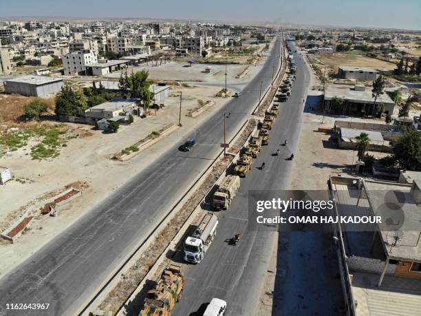 Picture taken on August 19, 2019 shows an aerial view of a convoy of Turkish military vehicles passing through Maaret al-Numan in Syria's northern...