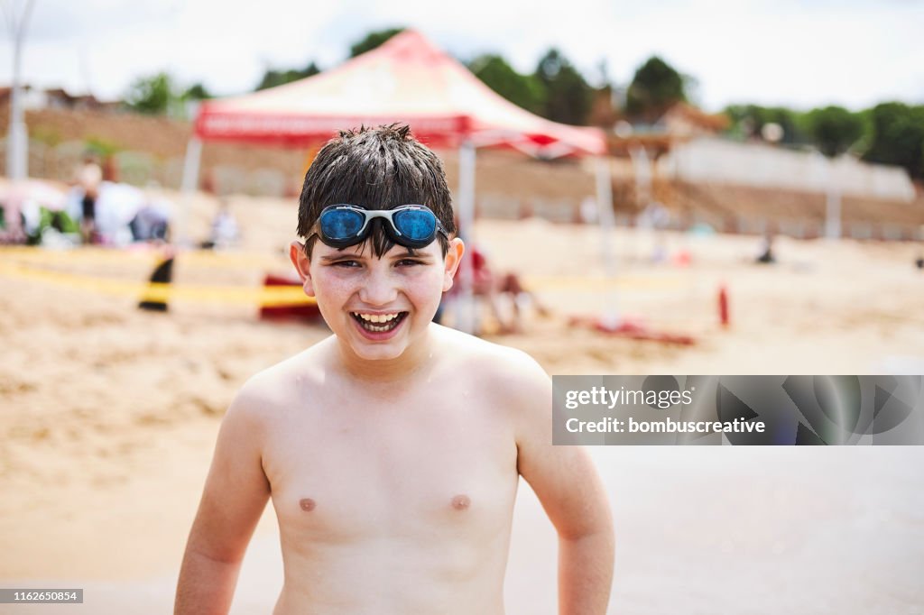 Lycklig tonårs pojke på stranden