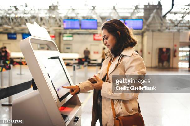 frau checkt am flughafen ein - selbstbedienung stock-fotos und bilder