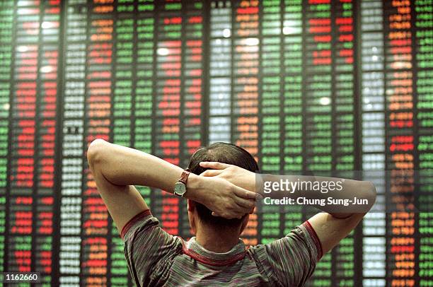 South Korean stock investor watches an electronic share price display September 13, 2001 at the stock exchange in Seoul, South Korea as share prices...
