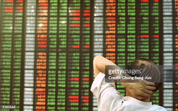 South Korean stock investor watches an electronic share price display September 13, 2001 at the stock exchange in Seoul, South Korea as share prices...