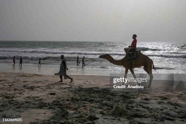 Man is seen on a camel at a beach in Nouakchott, Mauritania on August 19, 2019. West African country of Mauritania has a coastline of 754 kilometers...