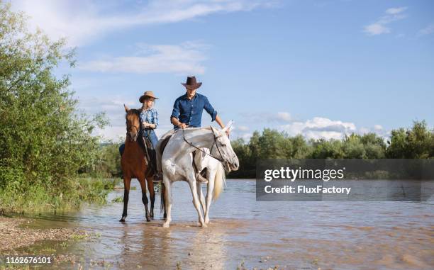 ranch couple taking their horses for a short walk - cool river ranch stock pictures, royalty-free photos & images