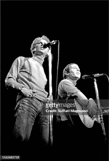 Paul Simon, looking upwards and Art Garfunkle, hands in his pockets, performing on stage at the Monterey International Pop Festival who recorded with...