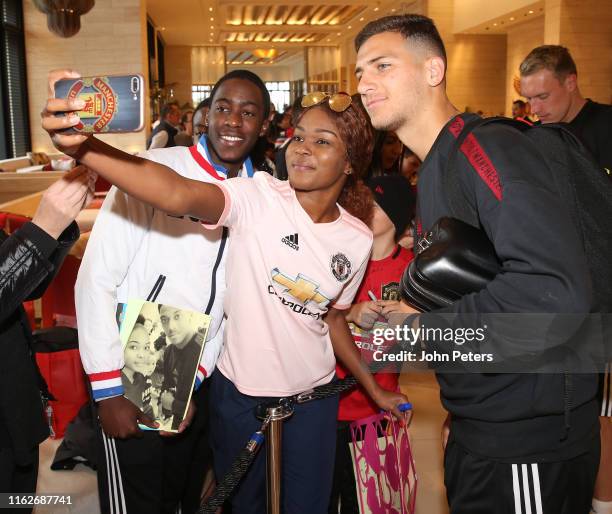 Diogo Dalot of Manchester United signs autographs as the players they leave the team hotel as part of their pre-season tour of Australia, Singapore...