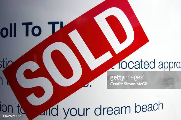 sold sticker on a real estate property sign - sold palabra en inglés fotografías e imágenes de stock