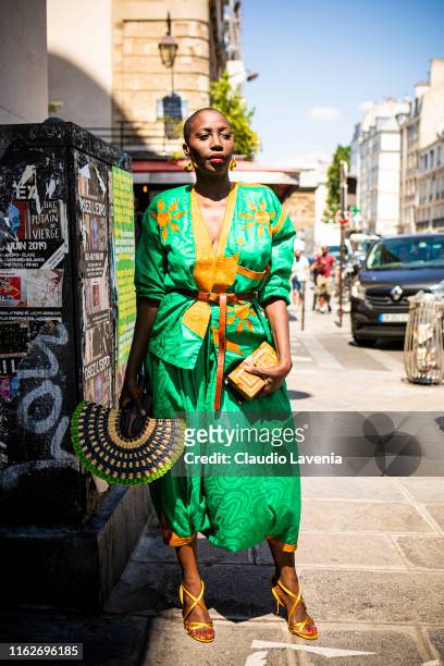 Guest, wearing a green and orange decorated top with matching pants and gold heels, is seen outside Jean Paul Gaultier show during Paris Fashion Week...