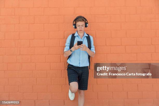 teen boy listening to music - teen boy shorts stockfoto's en -beelden