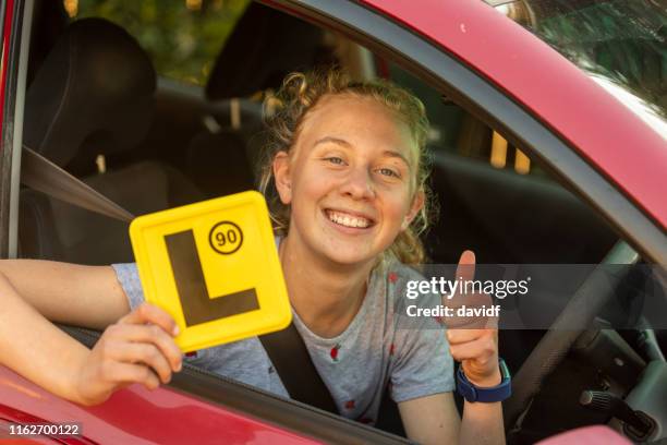 teenage girl celebrating learning to drive - driver license stock pictures, royalty-free photos & images