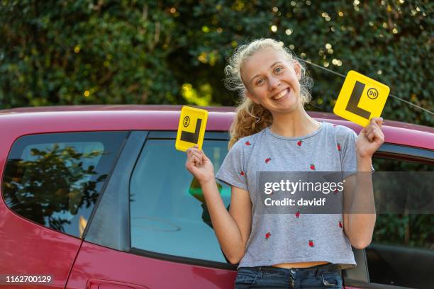 teenage girl feiert lernen zu fahren - learner driver stock-fotos und bilder