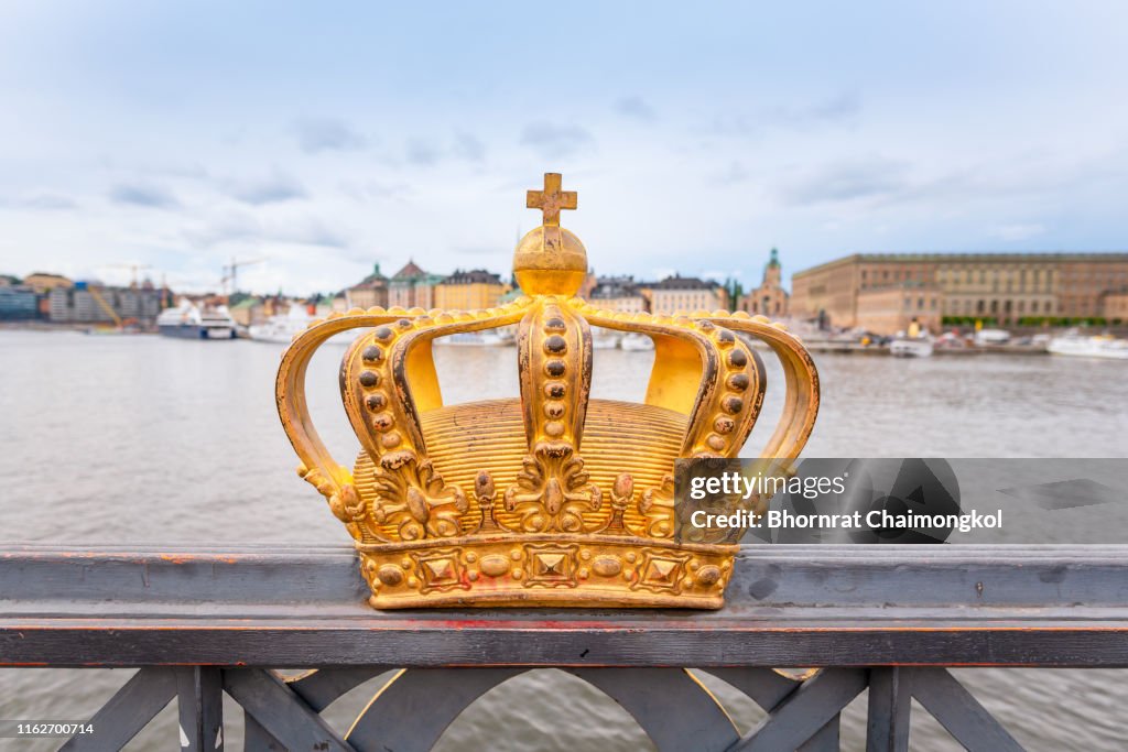 Gilded crown at the middle of Skeppsholmen bridge with Gamla stan in the background at Stockholm, Sweden