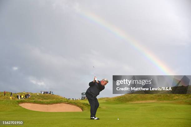 Darren Clarke of the Northern Ireland plays his second shot on the seventh hole under a rainbow during the first round of the 148th Open Championship...