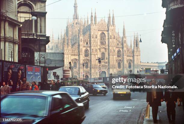 Traffic of cars and pedestrians near to the Piazza del Duomo in Milan. Photograph, Italy, Milan 1990.