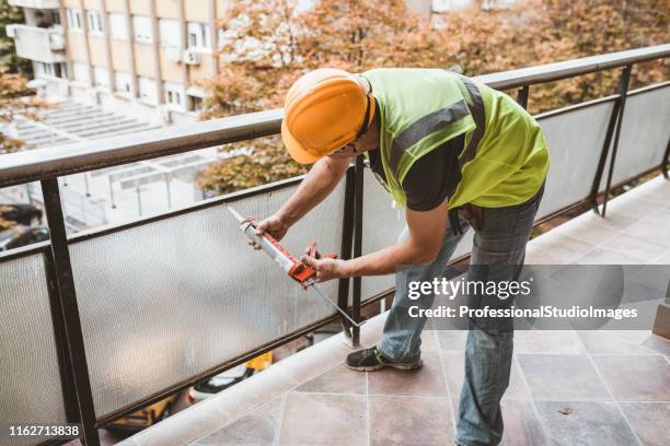 construction worker using silicone glue - glue stock pictures, royalty-free photos & images