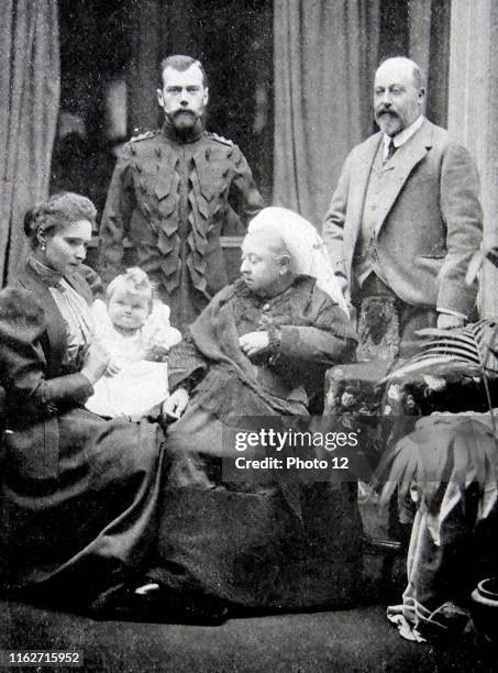 Photograph of Queen Victoria sat in the foreground alongside Tsarina Alexandra Fyodorovna and the infant Grand Duchess Olga Nikolaevna of Russia . In...