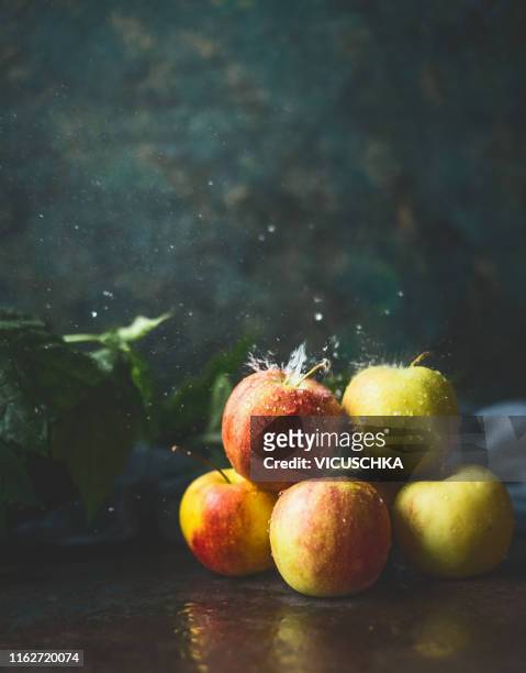 fresh seasonal apples with water splashing on dark table - apple water splashing stock pictures, royalty-free photos & images