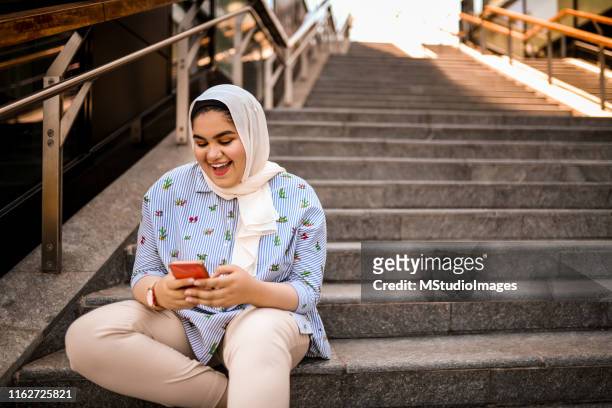 using mobile phone. - chubby arab stock pictures, royalty-free photos & images