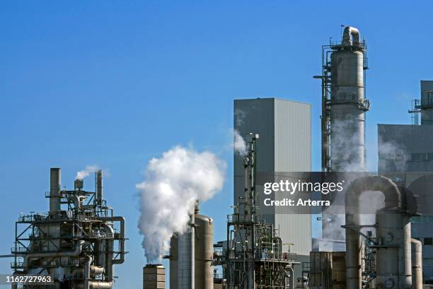 Smoke from chimneys at industrial estate showing BASF chemical production site in the port of Antwerp, Belgium.