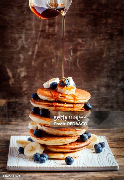 Pancakes with banana. Blueberry and maple syrup for a breakfast.