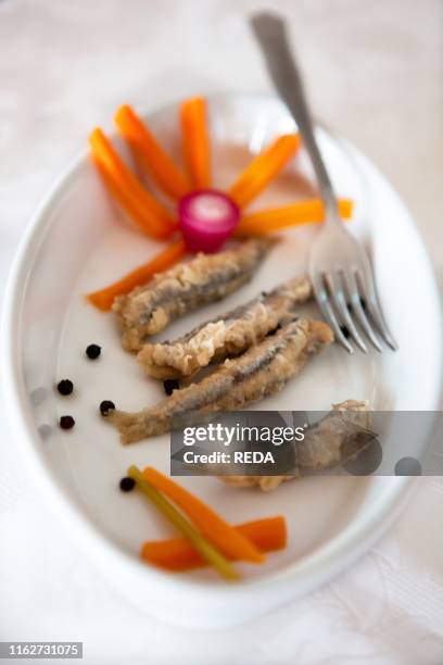 Antipasto di acciughe in agrodolce con carote e rapanelli.