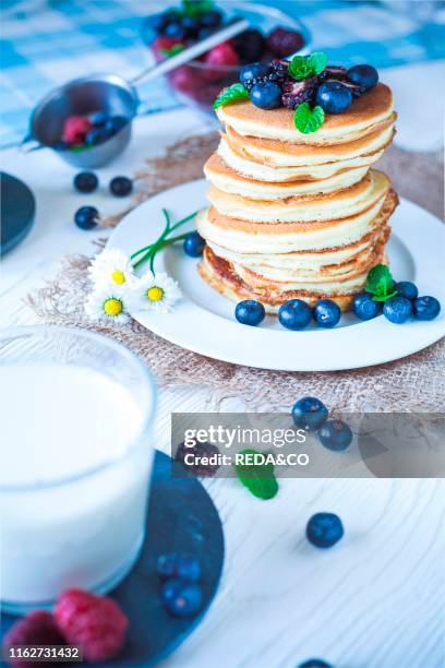 Delicious homemade pancakes with berries and milk.