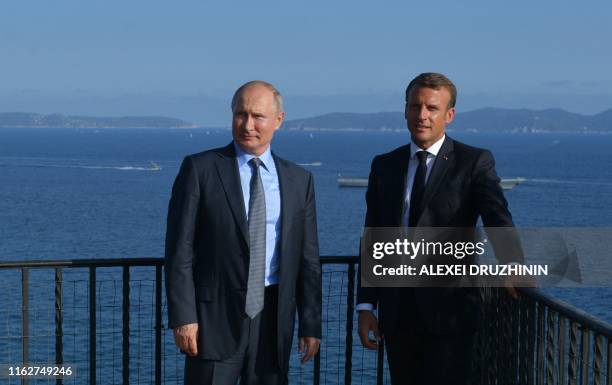 French President Emmanuel Macron and Russia's President Vladimir Putin pose, at his summer retreat of the Bregancon fortress on the Mediterranean...