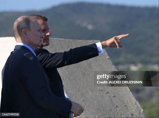 French President Emmanuel Macron gives some explanations to Russia's President Vladimir Putin, at his summer retreat of the Bregancon fortress on the...