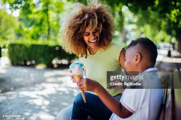 happy woman having ice cream with son - tomando sorvete imagens e fotografias de stock