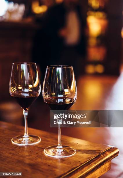 two glasses of red wine on a table - red wine glass stockfoto's en -beelden