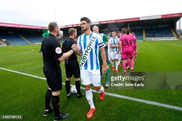 Christopher Schindler the captain of Huddersfield Town leads out his side wearing the new and controversial Paddy Power shirt before the game between...