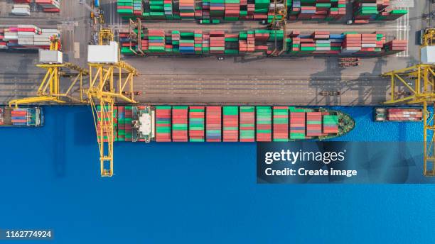aerial top view container ship at quayside loading container via crane for logistics, import export, shipping or transportation. - shipping container top view - fotografias e filmes do acervo