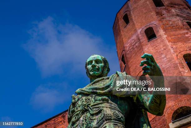 Julius Caesar, detail of the bronze statue; in the background, one of the tower of Porta Palatina, ancient Roman gate, 1st century BC, Turin,...