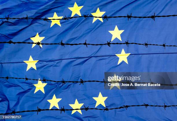 waving european union flag and barbed wire. - eurozone crisis stock pictures, royalty-free photos & images