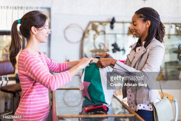 Woman using recyclable shopping bag for purchases in a clothes store