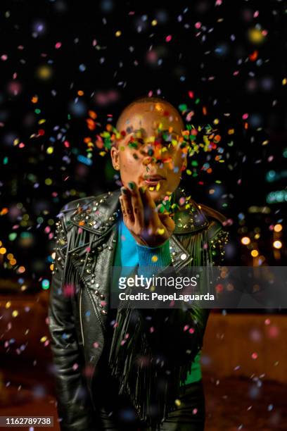 short haired woman blowing colorful confetti - dominican ethnicity stock pictures, royalty-free photos & images