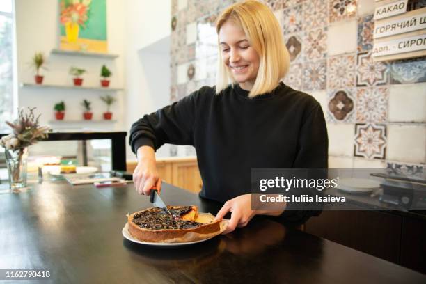 smiling cafe employee cutting pie at counter - cutting cake stock pictures, royalty-free photos & images