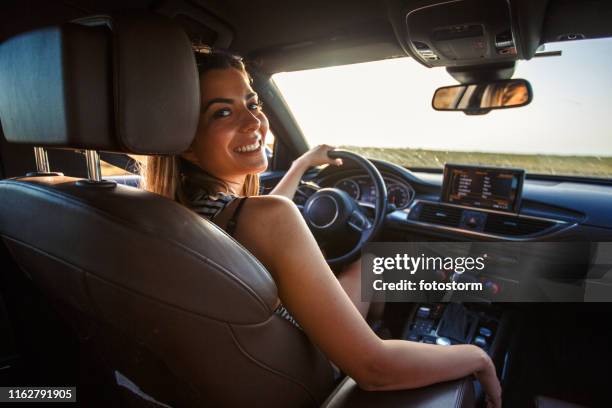 smiling young woman going on a road trip - woman driving stock pictures, royalty-free photos & images