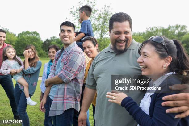 hispanisches paar genießt familientreffen - onkel stock-fotos und bilder