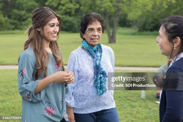 young woman talks with mom and grandma - young woman and senior lady in a park stock pictures, royalty-free photos & images