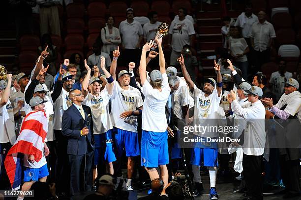 Dirk Nowitzki of the Dallas Mavericks holds the NBA Championship trophy as he and his teammates celebrate defeating the Miami Heat in Game Six of the...