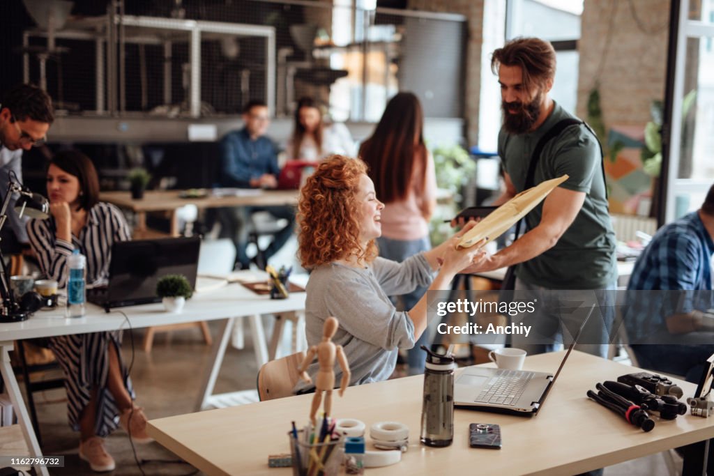 Woman getting a parcel from delivery man