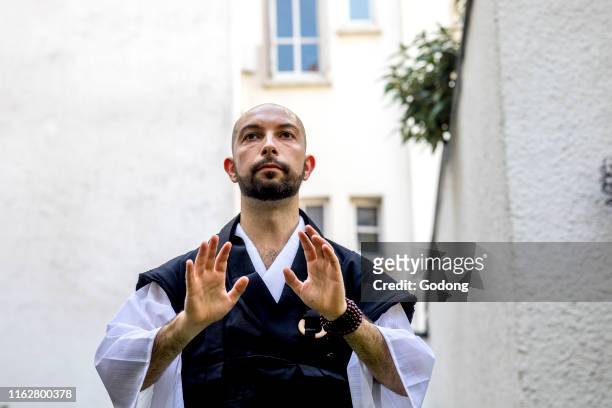 Zen sesshin in Paris, France. Retreatant practising qi gong.