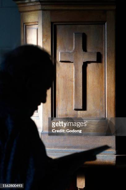 Protestant church. Shilouette of man at sunday service. France.