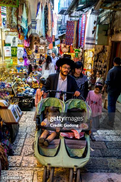 Orthodox jewish family going up with a pram in Jerusalem's old city, Israel.